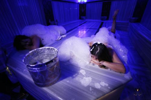 two women laying in a bathtub covered in bubbles at Vivaldi Park Hotel in Ankara