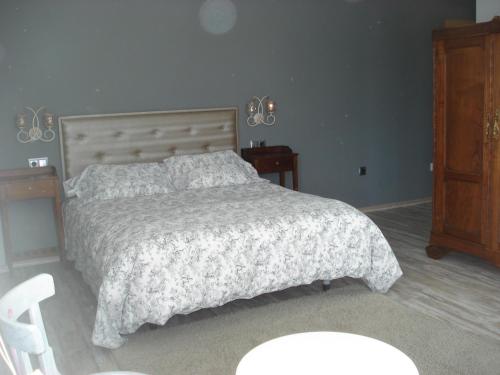 a bedroom with a bed and a wooden cabinet at Posada la Desmera in Isla