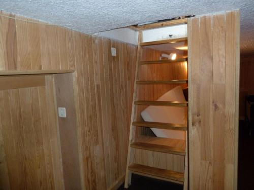 an empty closet with wooden walls and shelves at Appart Eterlou Chamrousse in Chamrousse