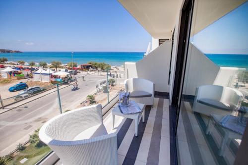 a balcony with white chairs and a view of the ocean at Victoria Palace Cefalù in Cefalù