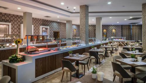 a restaurant with tables and chairs and a bar at Pavlo Napa Beach Hotel in Ayia Napa