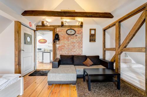 a living room with a couch and a brick wall at Dom & House – Apartments Port Monte Cassino in Sopot