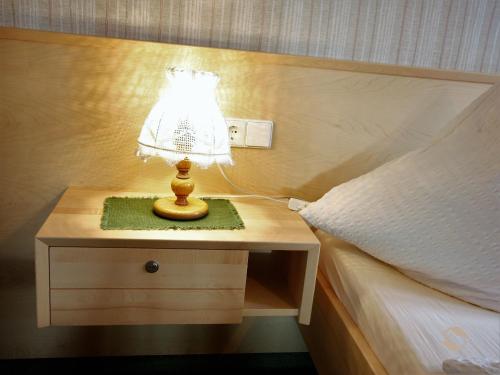 a lamp on a night stand next to a bed at Gästehaus Wissler in Todtnau