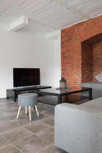 a living room with a tv and a table and a couch at Apartament w starym browarze 2 in Kłodzko