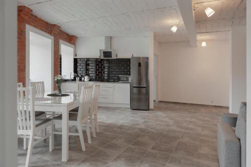 a kitchen and dining room with a table and a refrigerator at Apartament w starym browarze 2 in Kłodzko