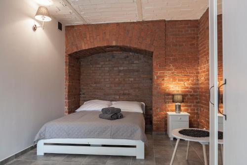 a bedroom with a bed with a brick wall at Apartament w starym browarze 2 in Kłodzko
