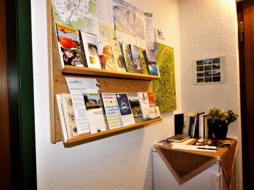 a wall with a bulletin board and a shelf with books at Gästehaus Wissler in Todtnau