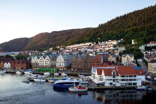 a town with boats in the water next to a city at Magic Hotel & Apartments Kløverhuset in Bergen