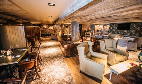 a living room with couches and tables and chairs at Bowfield Hotel and Spa in Howwood