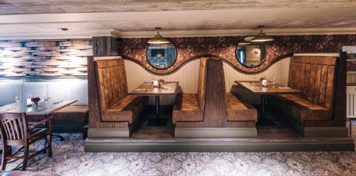 a restaurant with wooden booths and tables in a room at Bowfield Hotel and Spa in Howwood