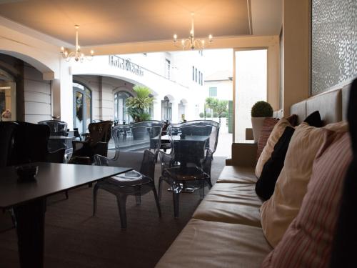 a living room with a couch and a table and chairs at Hotel Giulia Ocean Club in Qualiano