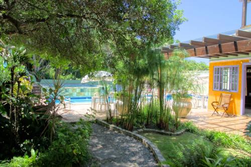 a backyard with a pool and a house at Pousada Aguas Claras in Búzios