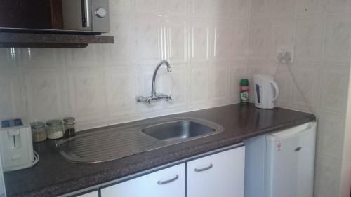 a kitchen with a sink and a counter top at Sunset View Guest House in Piggs Peak