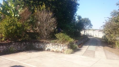 a road with a stone wall next to a street at Sunset View Guest House in Piggs Peak