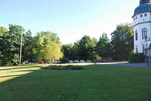 a building with a grass field in front of a building at Hellidens Slott in Tidaholm