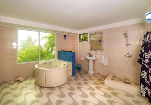 a bathroom with a large tub and a sink at Royal Palm Holiday Apartment in Méro