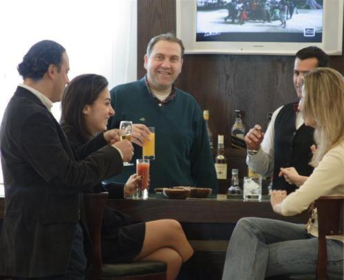a group of people sitting around a bar with drinks at Padova Hotel in Beirut