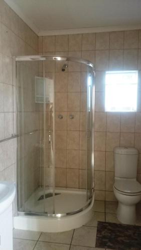a bathroom with a shower and a toilet at Sunset View Guest House in Piggs Peak