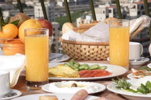 a table with plates of food and two glasses of orange juice at Padova Hotel in Beirut