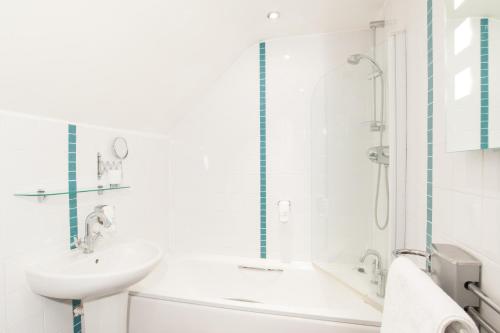La salle de bains blanche est pourvue d'un lavabo et d'une douche. dans l'établissement Unicorn, Gunthorpe by Marston's Inns, à Lowdham
