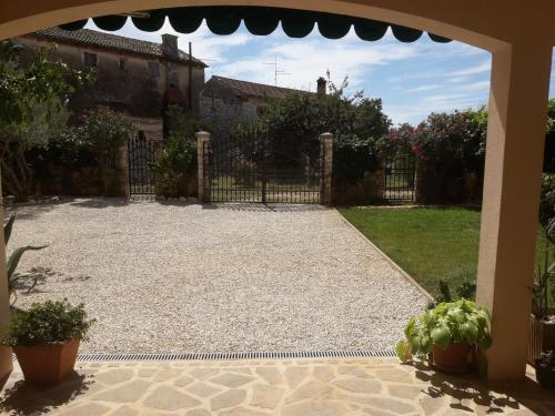 uma entrada para um quintal com uma cerca e plantas em Villa Kortina em Basanija