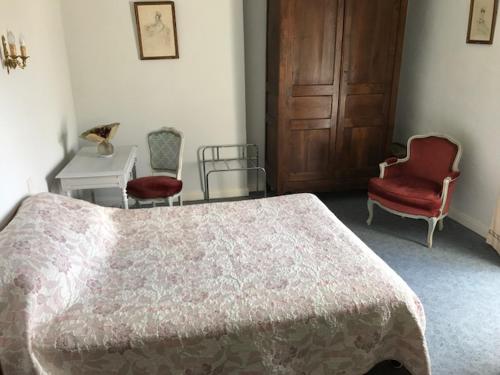une chambre avec un lit, deux chaises et une table dans l'établissement Appartement, à Villemoisan