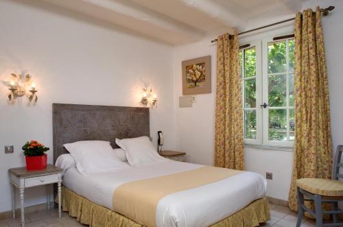 a bedroom with a large bed and a window at Le Mas Des Sables in Aigues-Mortes