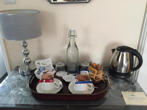 a tray with dishes and a bottle on a table at Dolphin Guest House in Looe