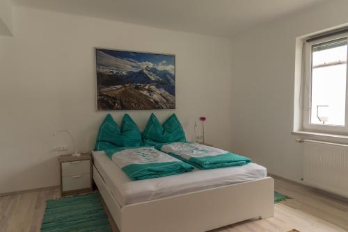 a bedroom with a bed with blue pillows on it at Apartment Sofia in Bodensdorf