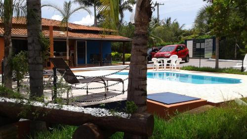 a house with a hammock and a swimming pool at Pousada Recanto Solar dos Pássaros in Olímpia