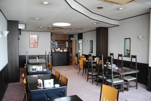 un comedor con mesas y sillas en un restaurante en Kojima Puchi Hotel, en Kurashiki