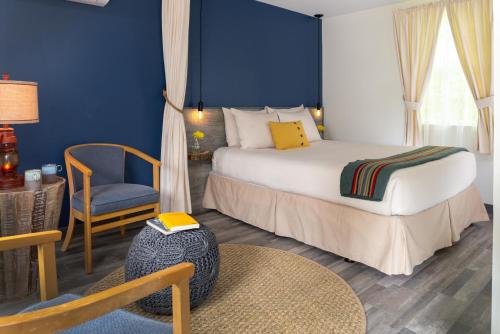 a hotel room with a bed and a chair at Treehouse Lodge in Woods Hole