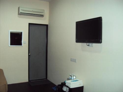 Habitación con TV de pantalla plana en la pared en Tai Pan Hotel, en Kuching