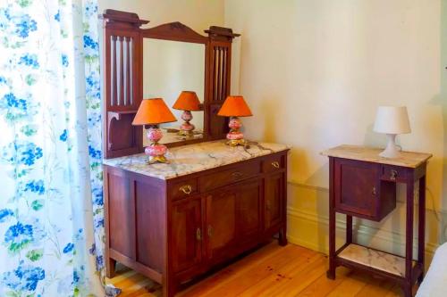 Un dormitorio con un tocador con dos lámparas. en Porto Countryside House, en Aguiar de Sousa