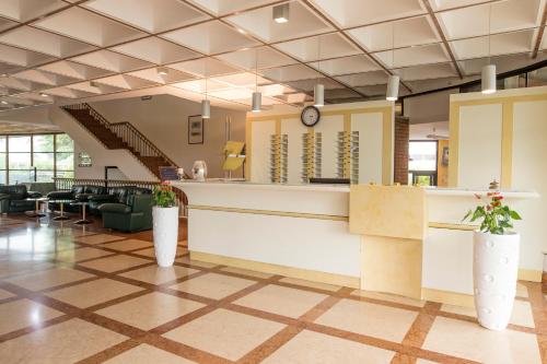 a lobby with a waiting area with chairs and a clock at Hotel Cangrande Di Soave in Soave