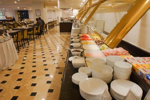 a buffet line with white bowls and plates at Best Western PLUS Gran Hotel Morelia in Morelia