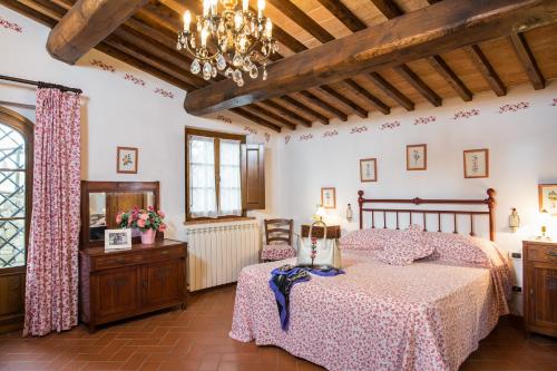 a bedroom with a bed and a chandelier at Ormanni nel Chianti Classico in Barberino di Val dʼElsa