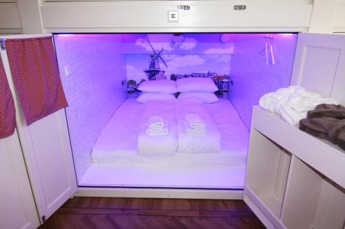 a room with a bed in a purple room at De Bedstee Boutique Capsules in Amsterdam