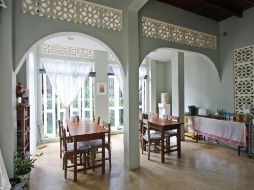 a dining room with a table and chairs at Lada House in Lampang