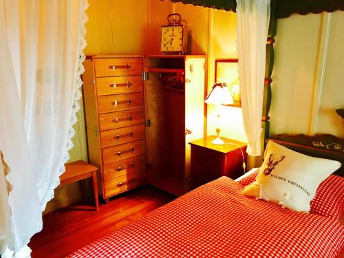 a bedroom with a bed and a dresser at Auberge de l'Assesseur - Mont-Soleil in Saint-Imier