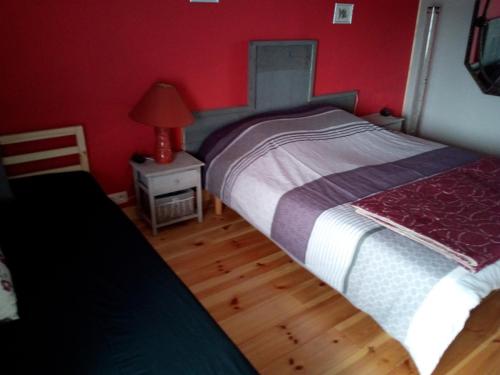 a bedroom with a bed and a table with a lamp at Le Relais du Moulin in Gedinne