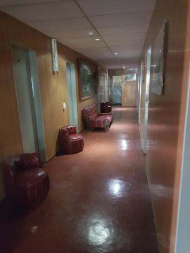 a hallway with couches and chairs in a building at Hotel Belgrano in Perito Moreno