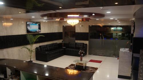 a lobby with a couch and a table and a tv at Kani Residency Hotel in Tuticorin