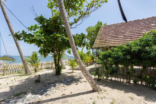 a house on the beach with palm trees at Azure Tides Marari in Mararikulam