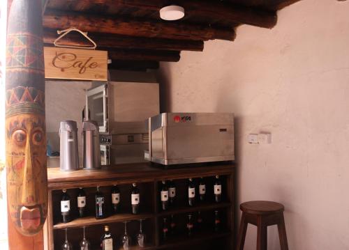 a counter with bottles of wine and a microwave at Hotel Otti Colonial in Monguí