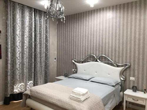 a bedroom with a white bed and a chandelier at Donna Margharet in Crotone