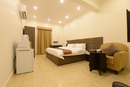 a hotel room with a bed and a chair at Top View - شقق المنظر in Al Hofuf