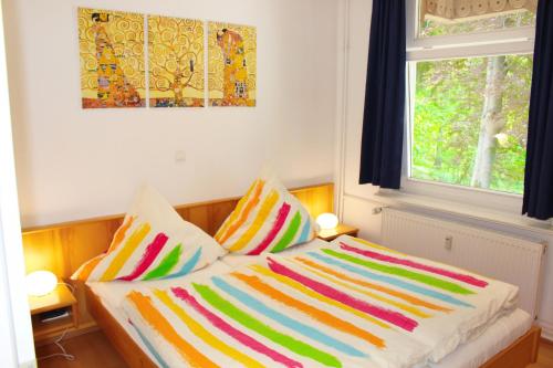 łóżko z kolorowymi kocami i poduszkami w pokoju w obiekcie Ferienwohnung Villa Parkblick w mieście Oberhof