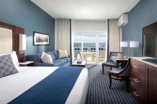 um quarto de hotel com uma cama e uma sala de estar em Ocean House Hotel at Bass Rocks em Gloucester