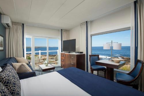 a hotel room with a bed and a view of the ocean at Ocean House Hotel at Bass Rocks in Gloucester